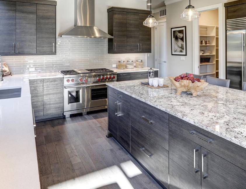 Modern kitchen with dark cabinets, stainless steel appliances, and a central island Modern kitchen with dark cabinets, stainless steel appliances, and a central island